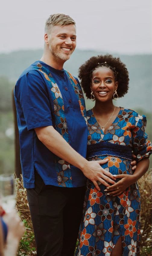 Presha Rivers met haar partner in bijpassende blauwe print, allebei lachend in de buitenlucht